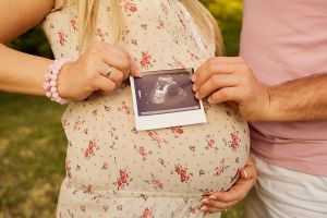 Couple holding sonogram images of their baby